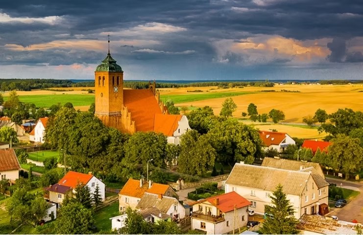 Vista aérea de Rakowitz (hoje Piaseczno, gmina Gniew) — a pequena localidade e sua igreja no meio das planícies